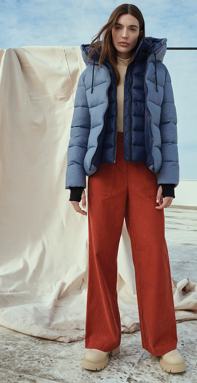 white woman in blue winter jacket and red pants