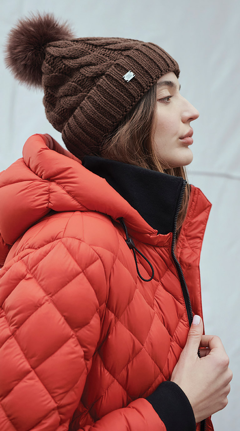 white woman in red winter jacket and toque