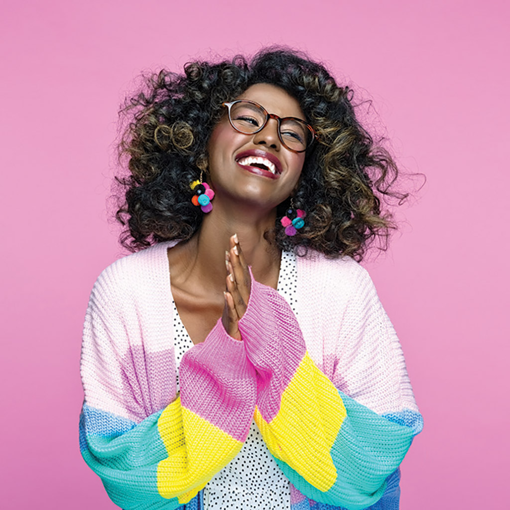 woman in colourful sweater on pink background