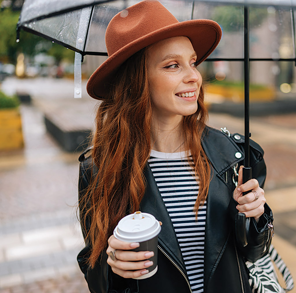 woman wearing hat holding umbrella
