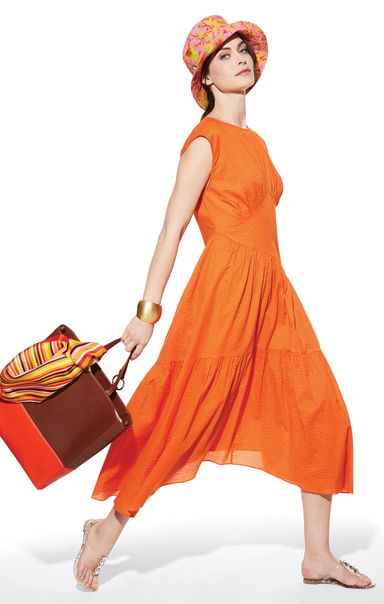 woman in orange dress holding purse